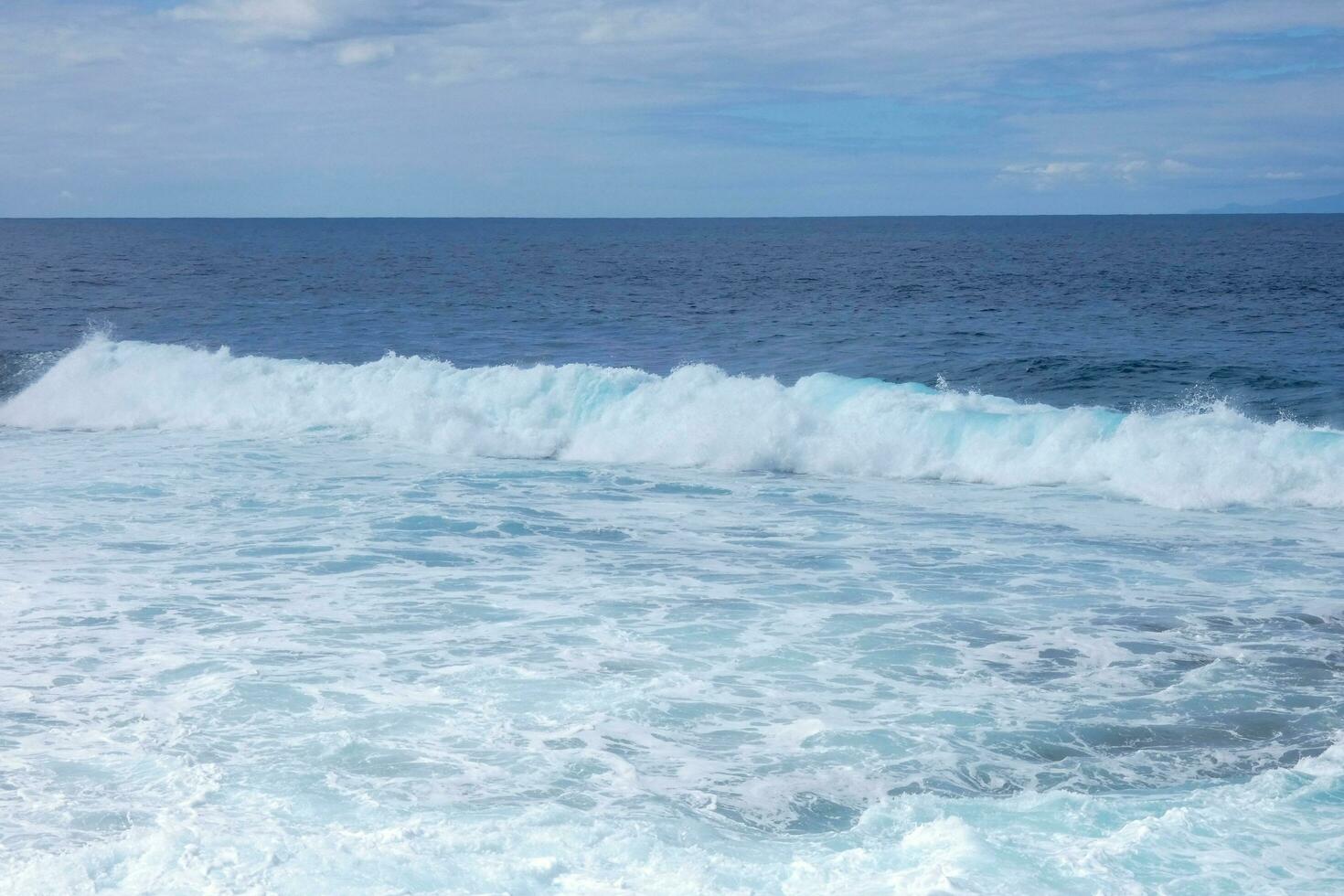 grande olas estrellarse en contra el rocas en el Oceano foto