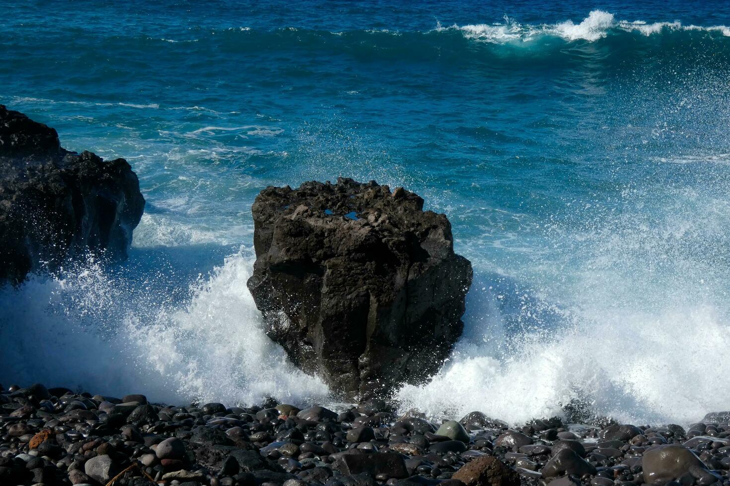 Large waves crashing against the rocks in the ocean photo