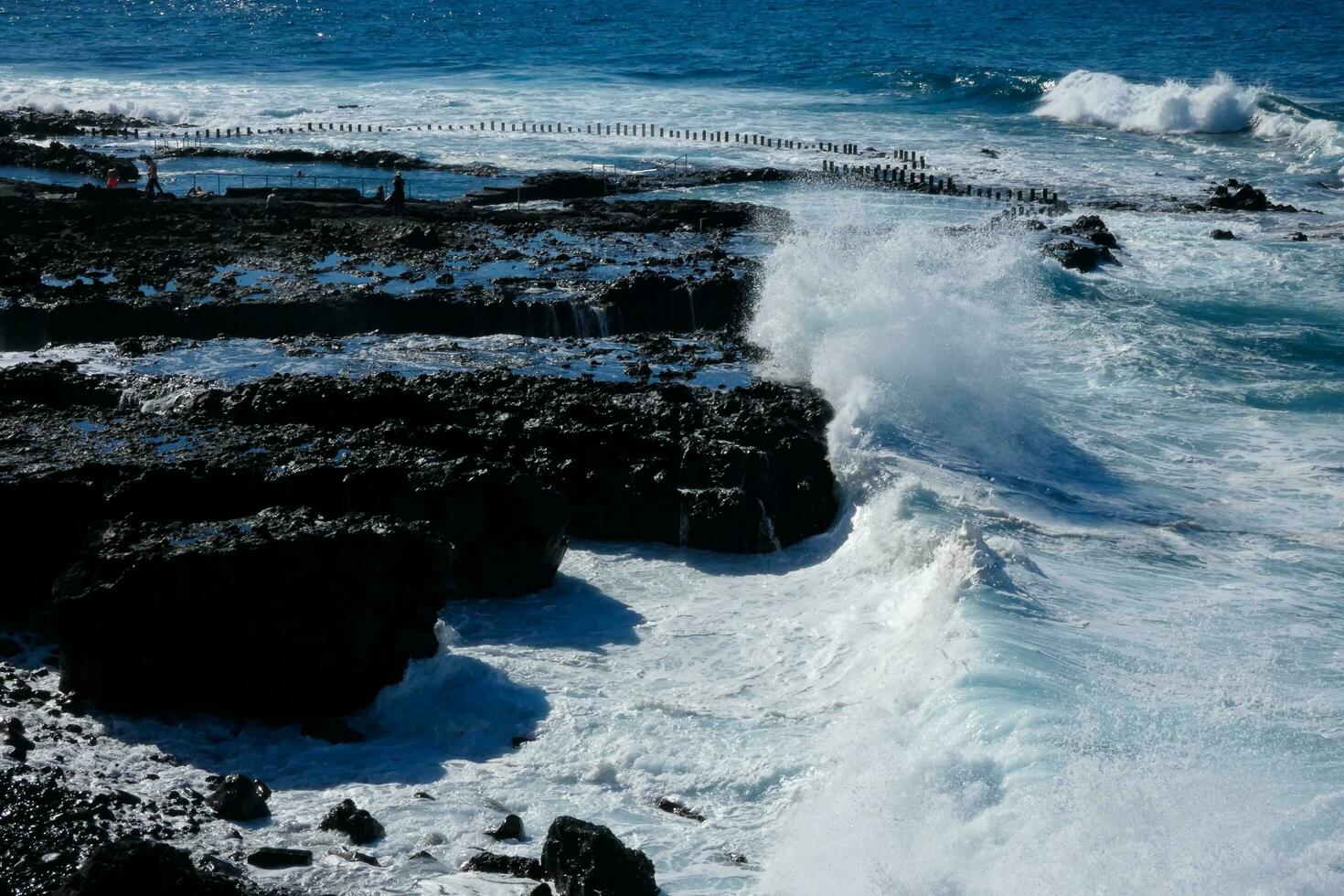 Large waves crashing against the rocks in the ocean photo