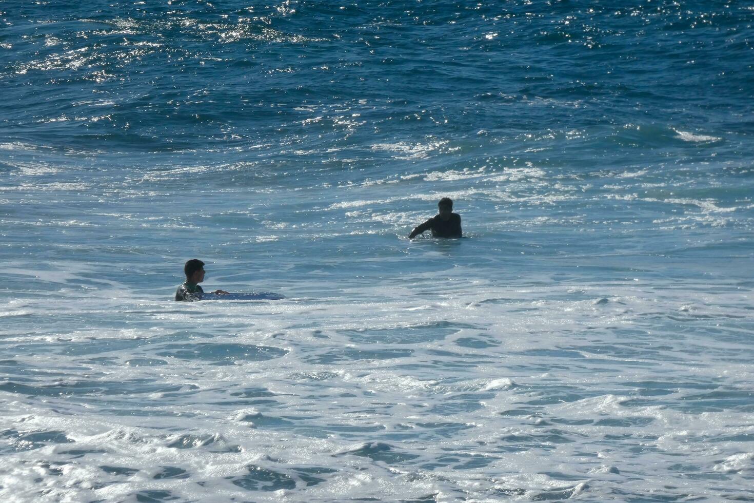 young athletes practising the water sport of surfing photo