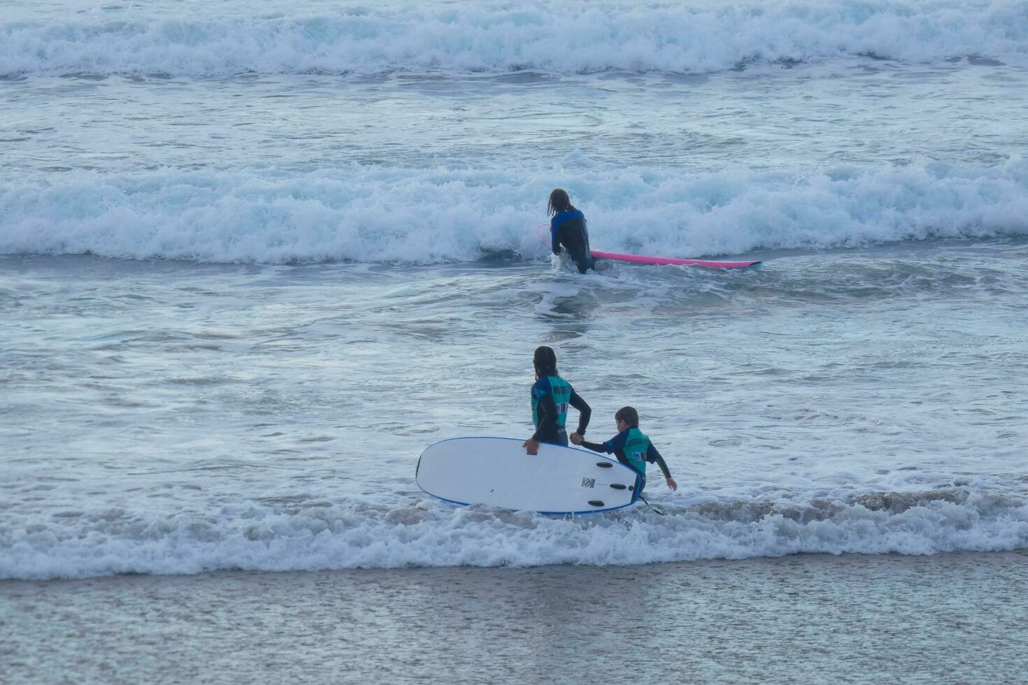 young athletes practising the water sport of surfing photo