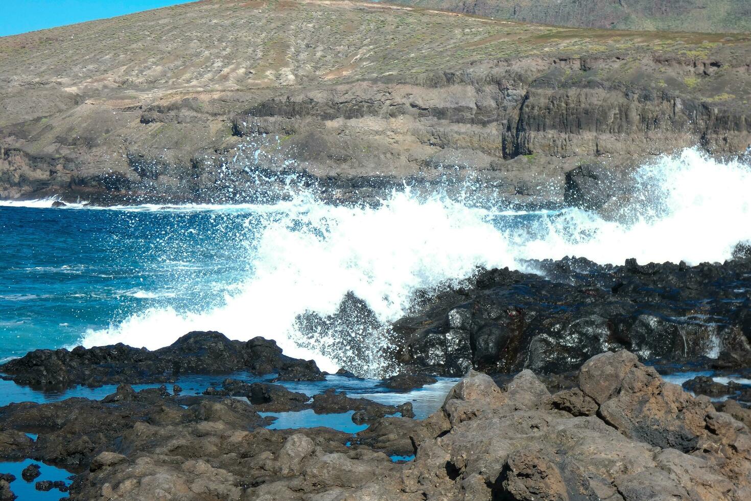 Large waves crashing against the rocks in the ocean photo