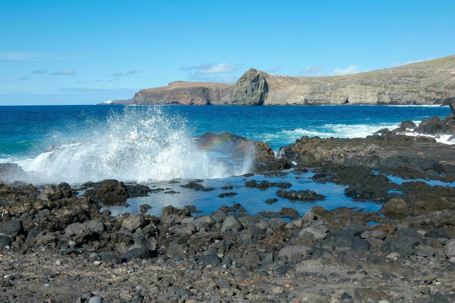 grande olas estrellarse en contra el rocas en el Oceano foto