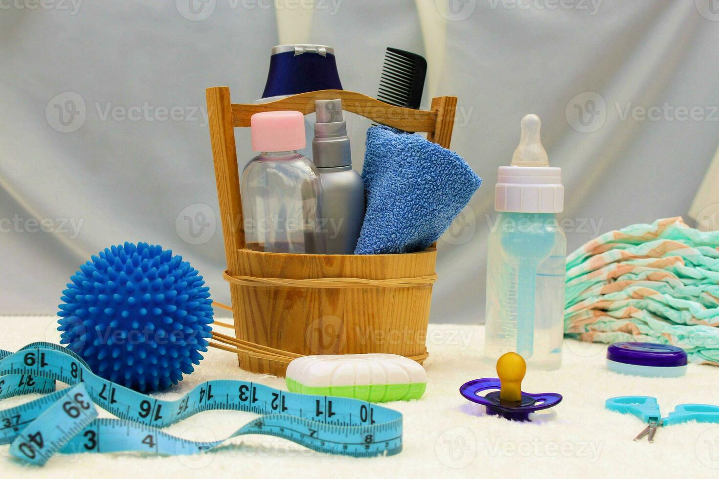 Baby accessories pacifier, bottle, disposable diapers, scissors, funds for the bath, the ball for massage, meter to measure the growth of the child, comb, oil for body photo