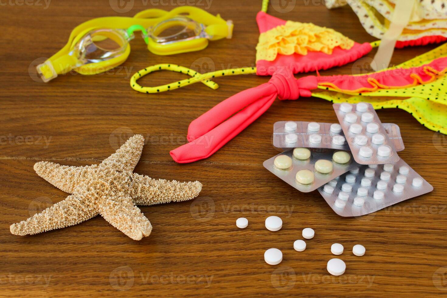 Summer beach accessories and medicine on the table. The concept of medication required in the journey photo