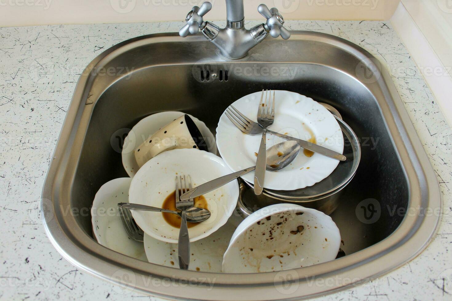 Dirty dishes plates, cup, forks, spoons in the sink photo