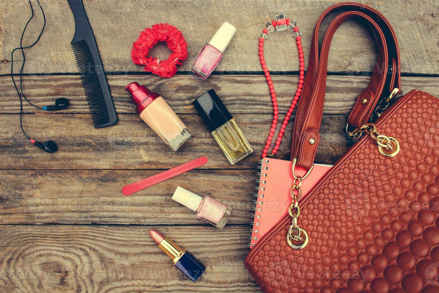 Things from open lady handbag. women's purse on wood background. Toned image. photo