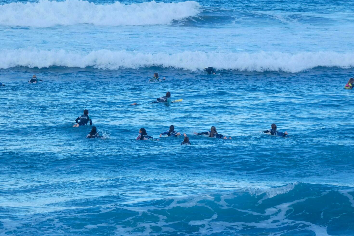 Surfers riding small ocean waves photo