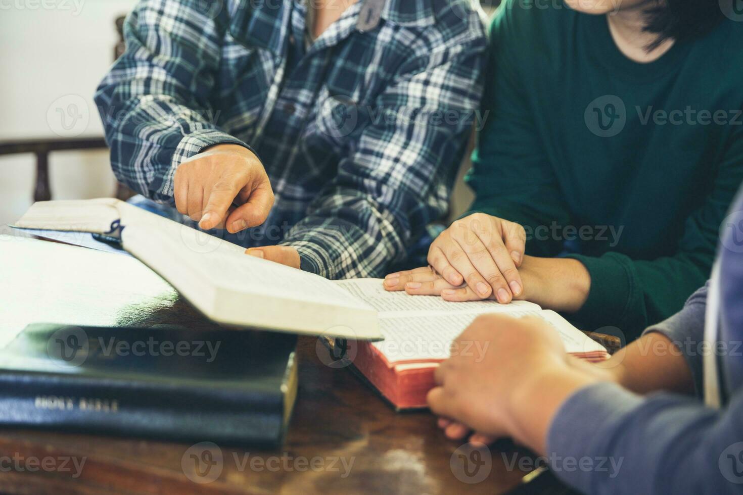 Small group of asian people praying worship believe. Teams of friends worship together before studying Holy bible. family praying together in church. Small group learning with prayer concept. photo