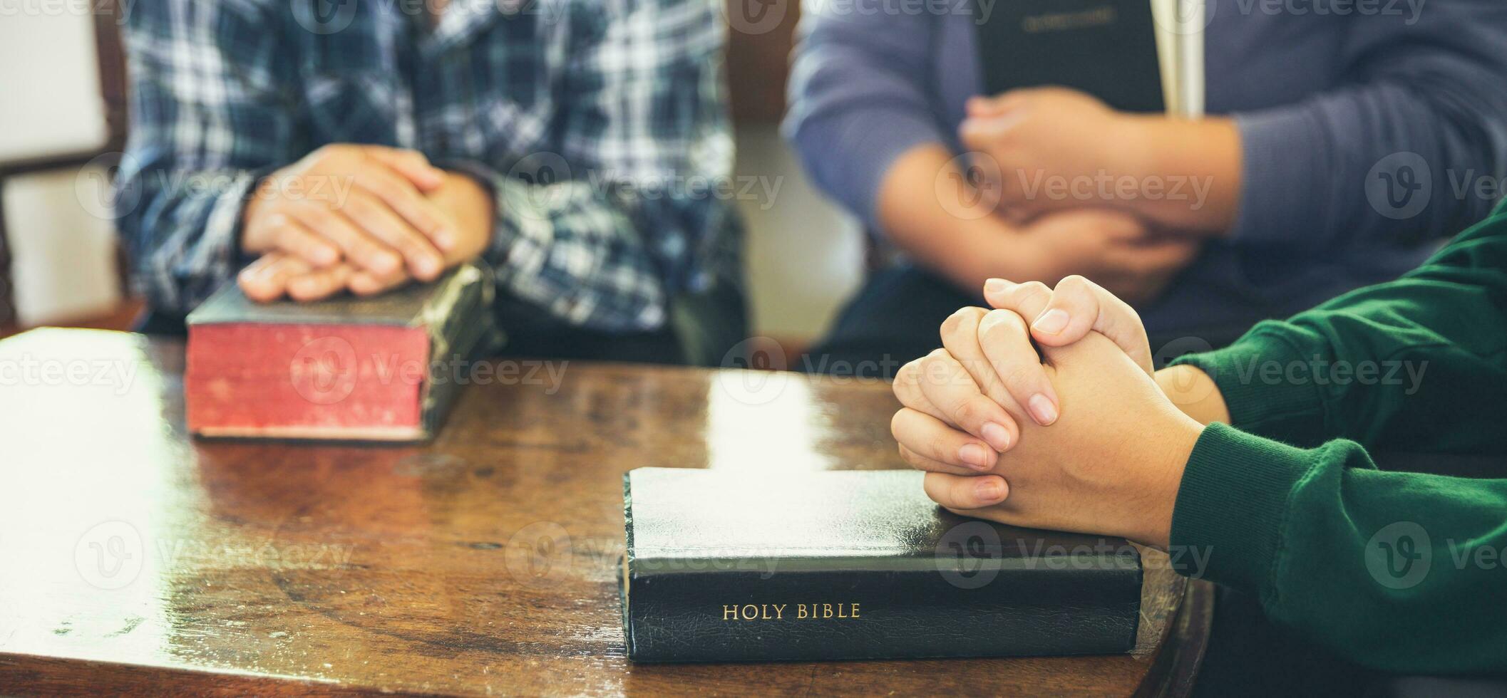 Small group of asian people praying worship believe. Teams of friends worship together before studying Holy bible. family praying together in church. Small group learning with prayer concept. photo