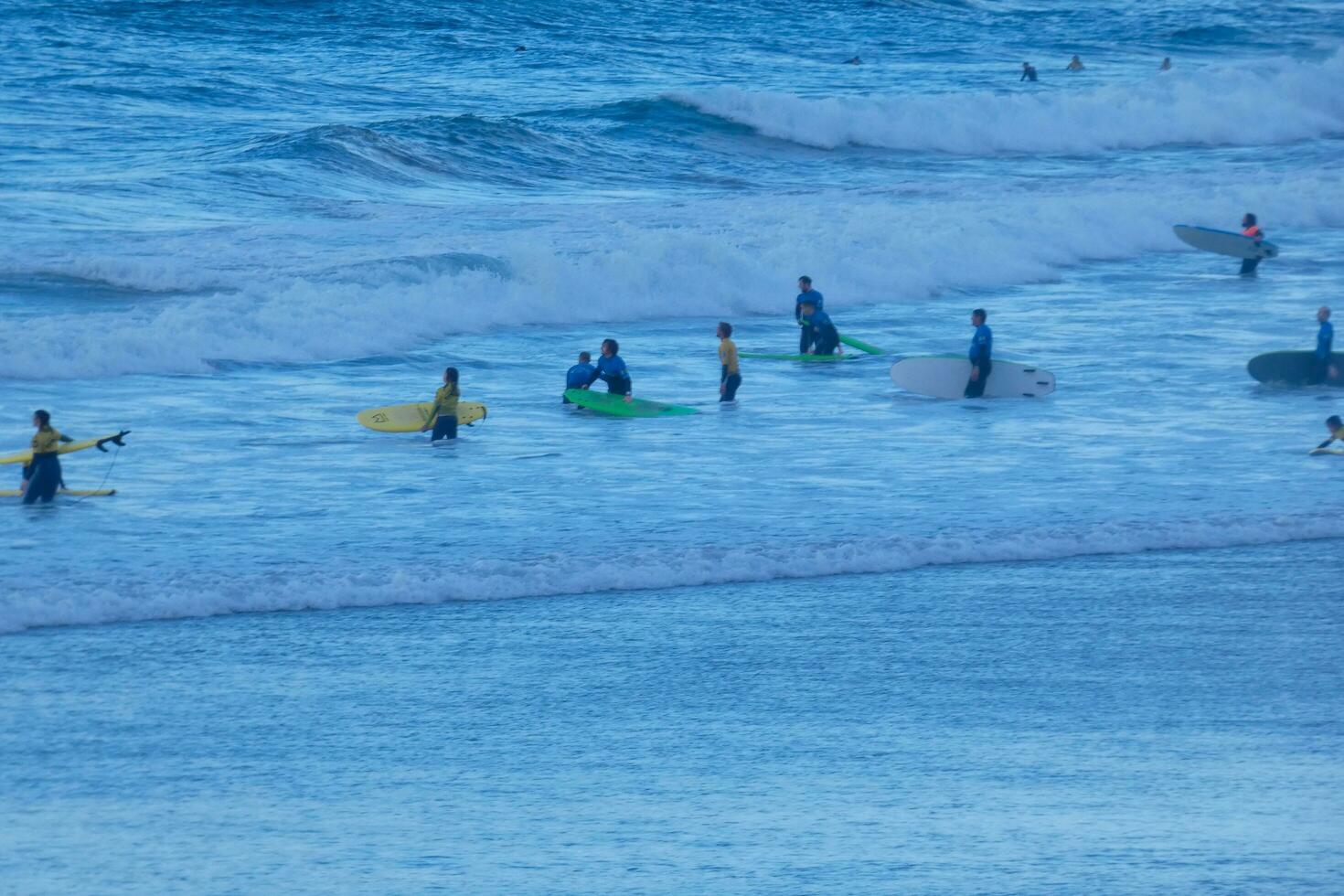 Surfers riding small ocean waves photo