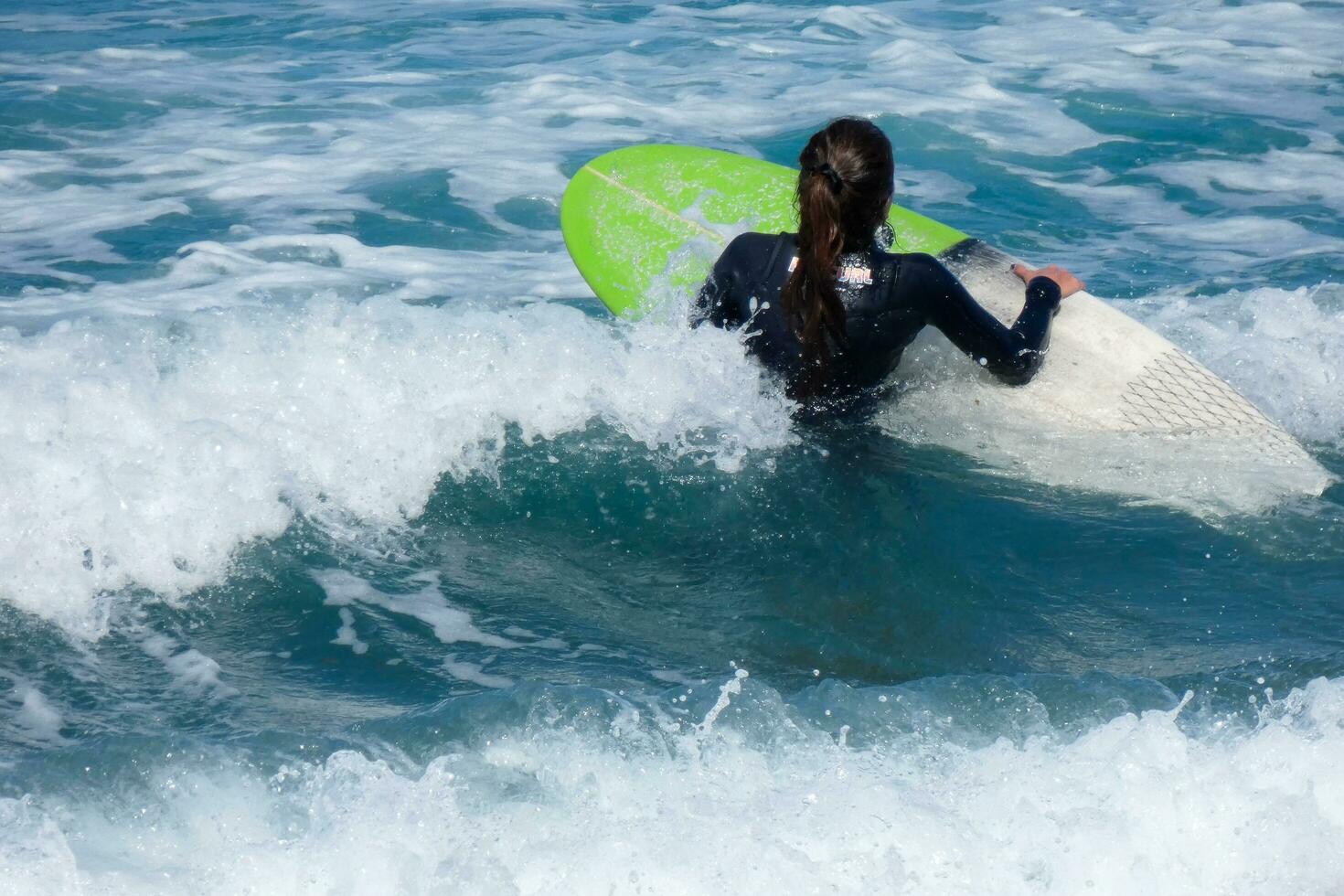 Surfers riding small ocean waves photo