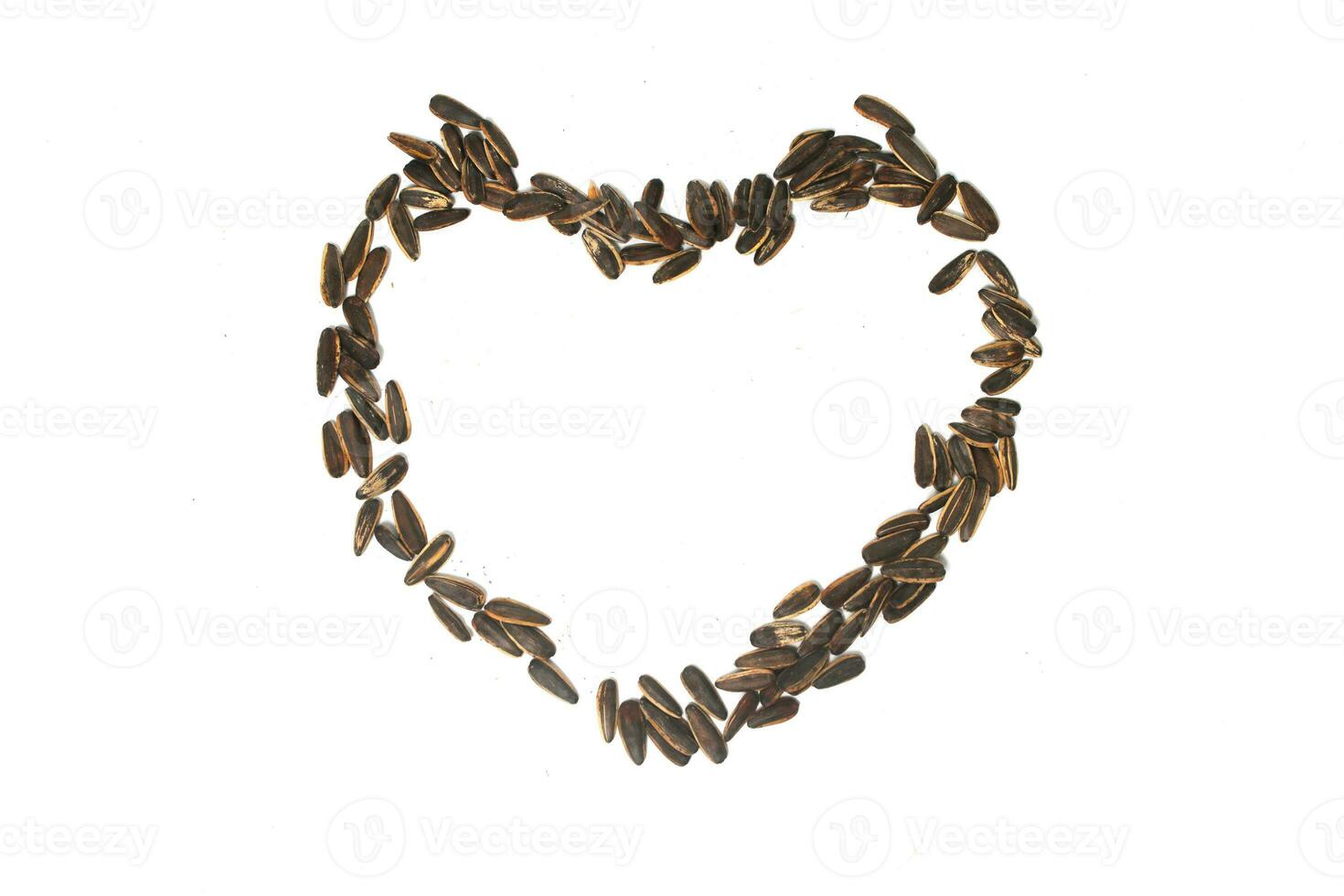 Sunflower seeds in the shape of a heart on white background. 23327878