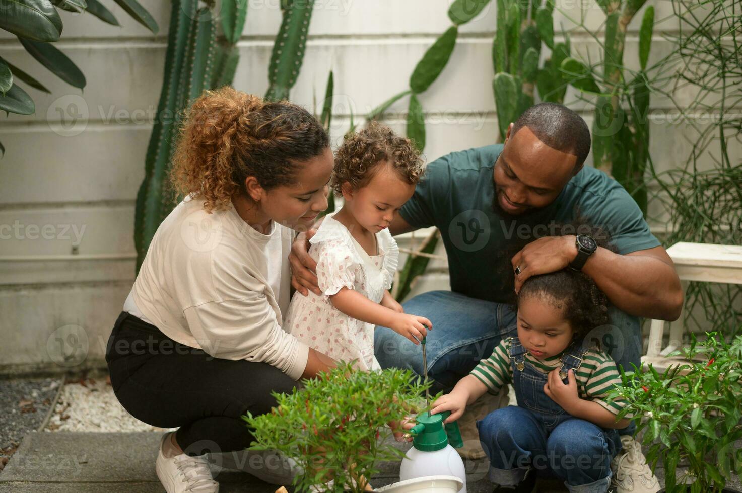 Happy African American family enjoying gardening at home photo