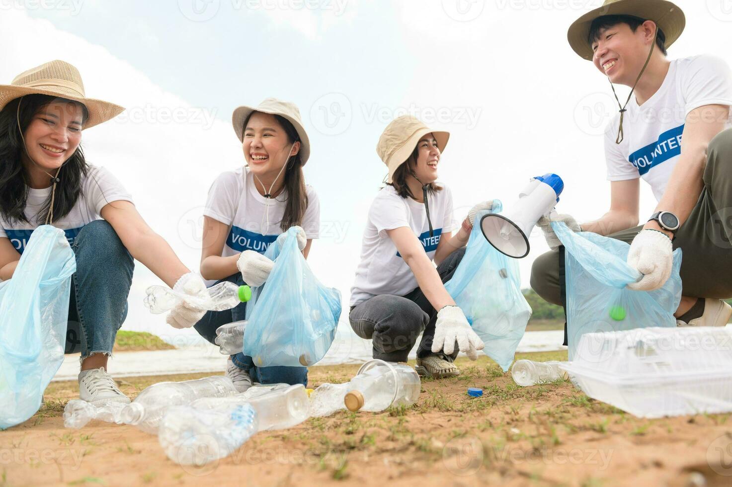 voluntarios desde el asiático juventud comunidad utilizando basura pantalones limpieza arriba naturaleza par foto