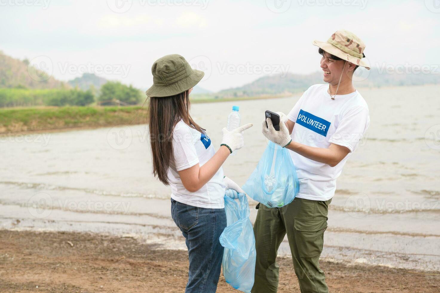 voluntarios desde el asiático juventud comunidad utilizando basura pantalones limpieza arriba naturaleza par foto