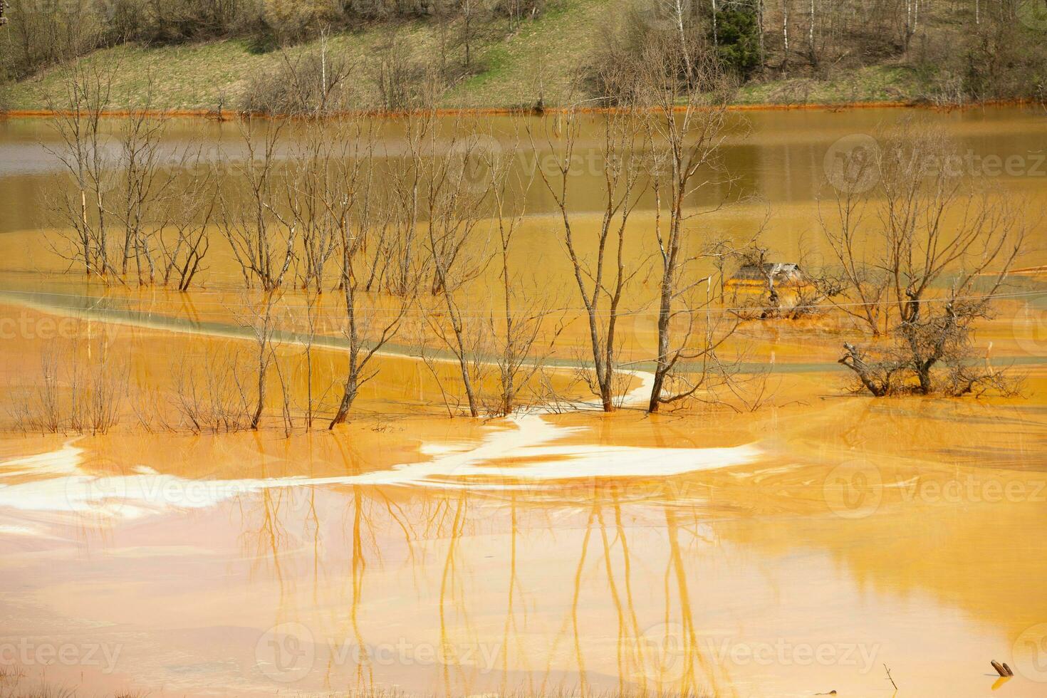 A lake contaminated with toxic waste in the western mountains of Romania. Nature pollution from copper mine. Ecological catastrophe or Environmental disaster photo