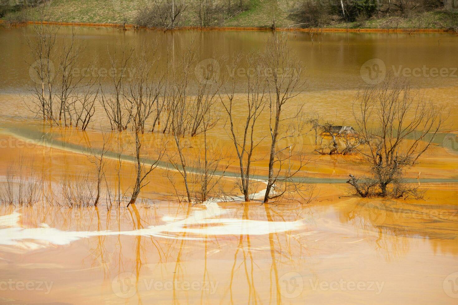 A lake contaminated with toxic waste in the western mountains of Romania. Nature pollution from copper mine. Ecological catastrophe or Environmental disaster photo