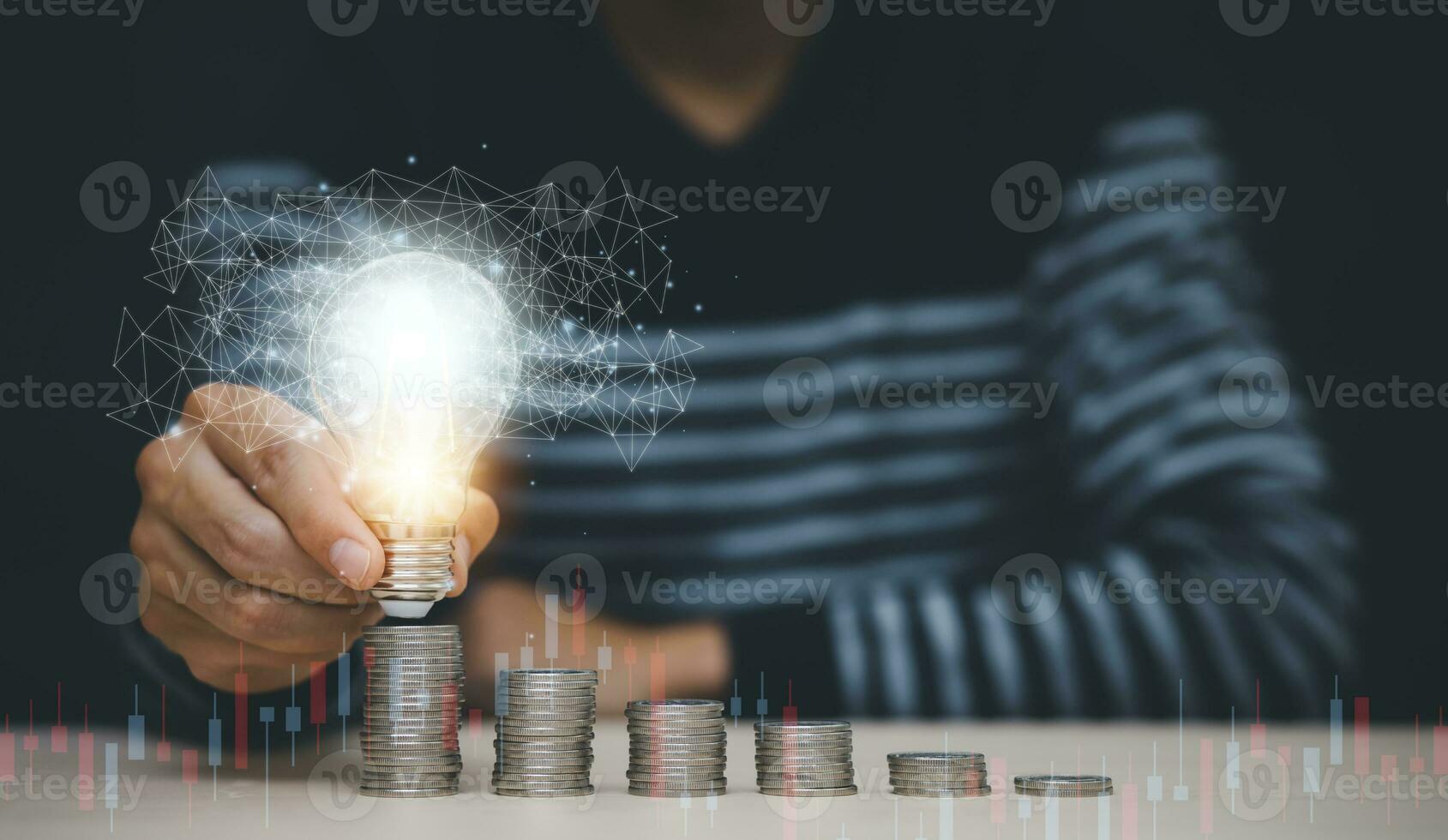 businessman hand holding light bulb with coins stacking on the desk. saving energy and money, the idea with innovation and inspiration concept saving energy and money photo