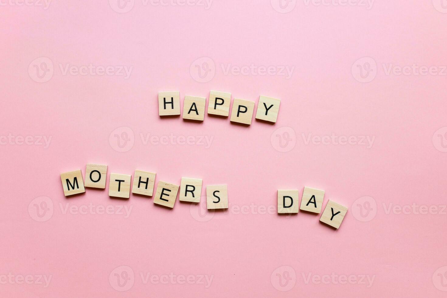Happy Mothers Day made of wooden letters on a pink background. Mothers day card photo