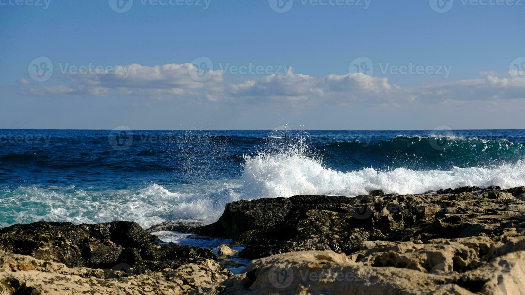 Blue sea wave and white foam and splash. Stone beach on island of Malta, no sandy beach. Summer holiday border frame concept. Tropical island vacation backdrop. Tourist travel banner design template. photo