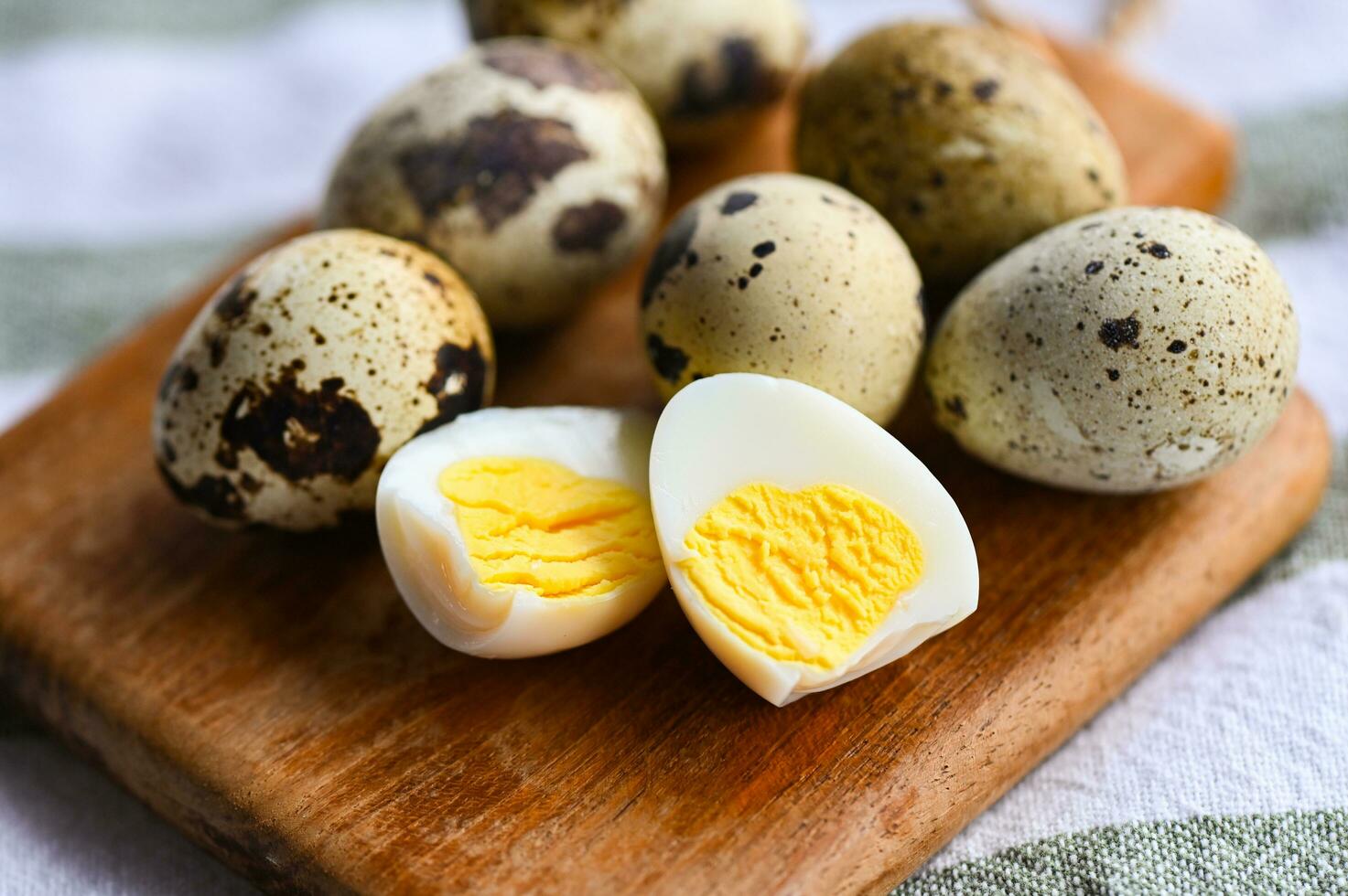 boiled eggs food, quail eggs on wooden plate, breakfast eggs with fresh quail eggs on table background photo