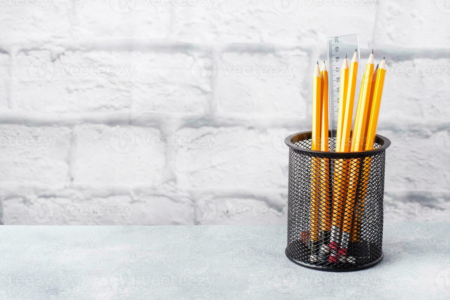 Set of bright simple pencils in a black stand on a gray table, copy space. photo