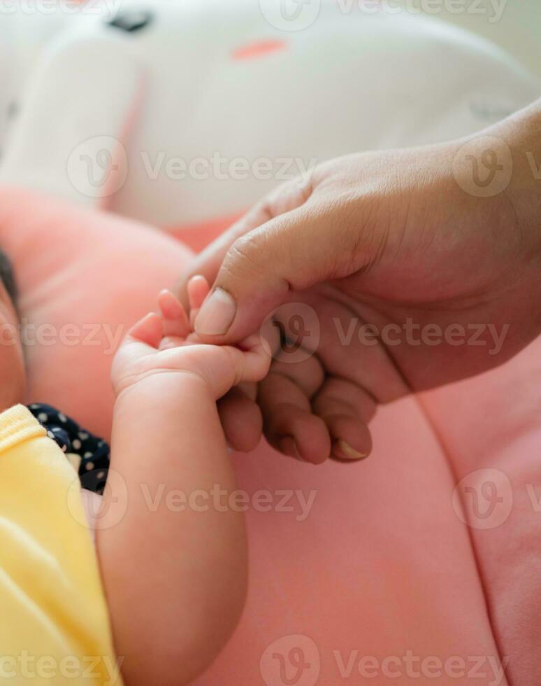 Newborn baby hand holding mother's hand, shallow depth of field photo