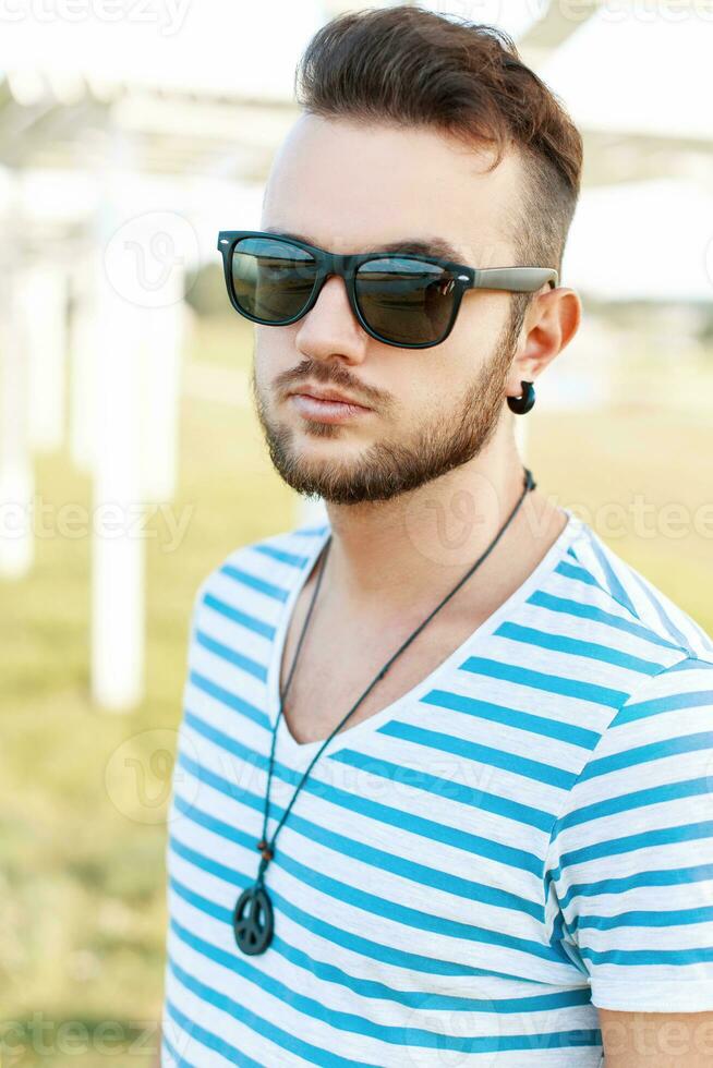 Sunny portrait of a handsome man with a beard on the beach. photo