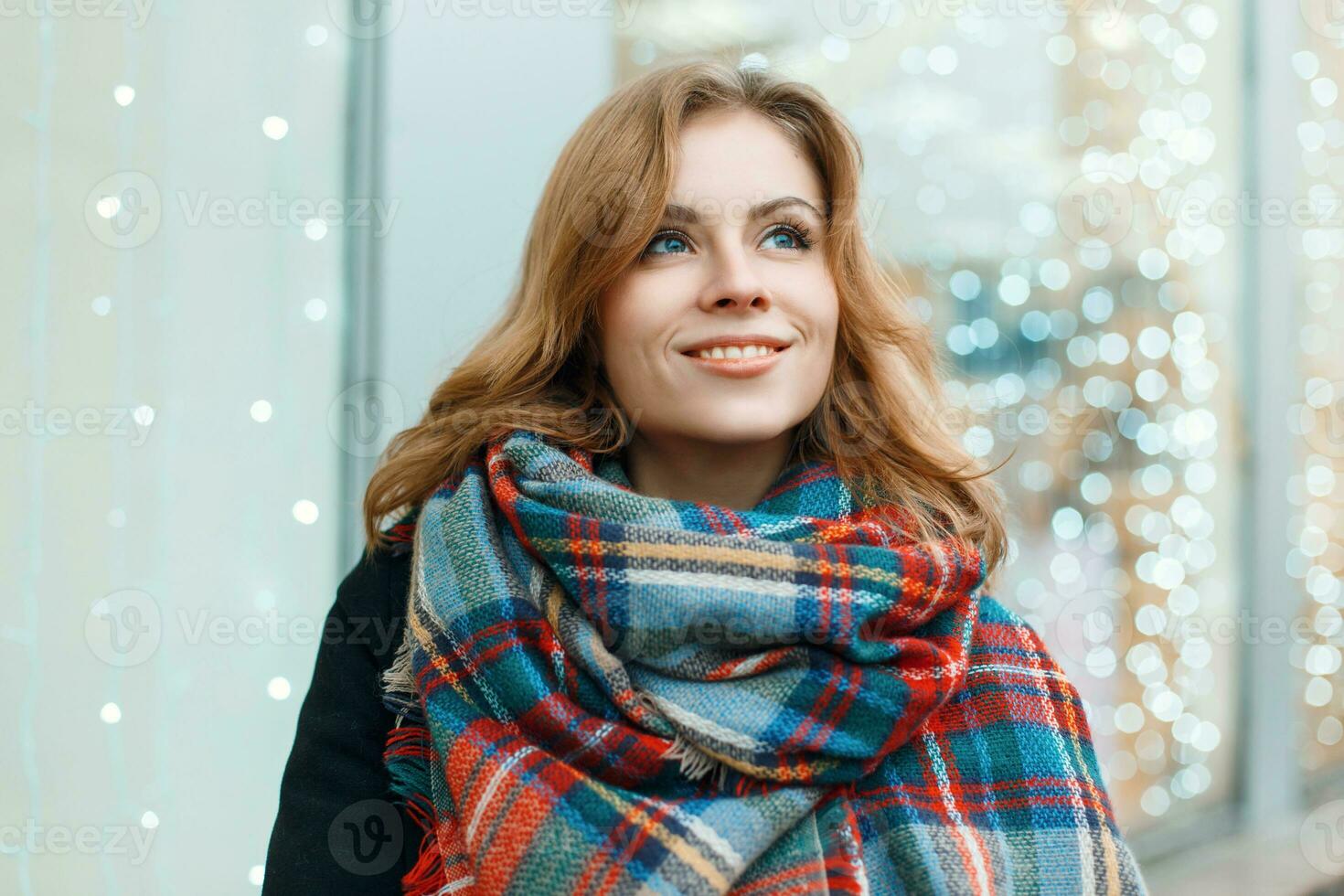 Sweet woman with a smile in a beautiful stylish scarf on the background ...