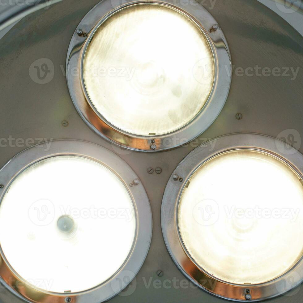 Bright light shines in the operating room. Metal surgical lamp. photo