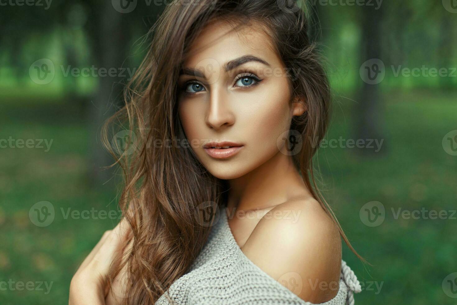 Portrait of a pretty woman with amazing blue eyes with the hairstyle in the park. photo