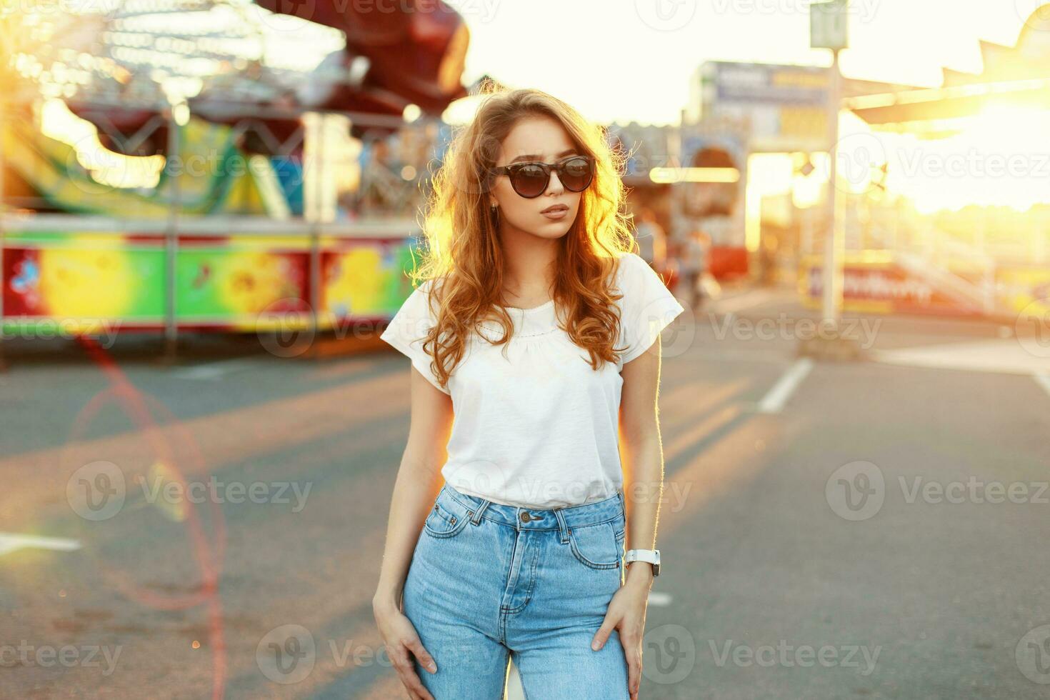 Young beautiful girl walks on the beach at sunset photo