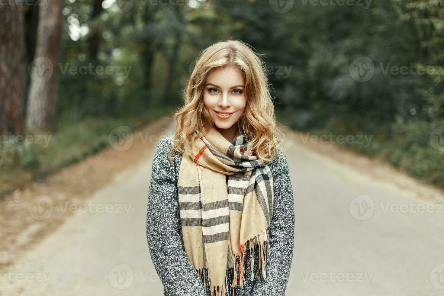 Beautiful young girl in a vintage scarf walks in autumn park. photo