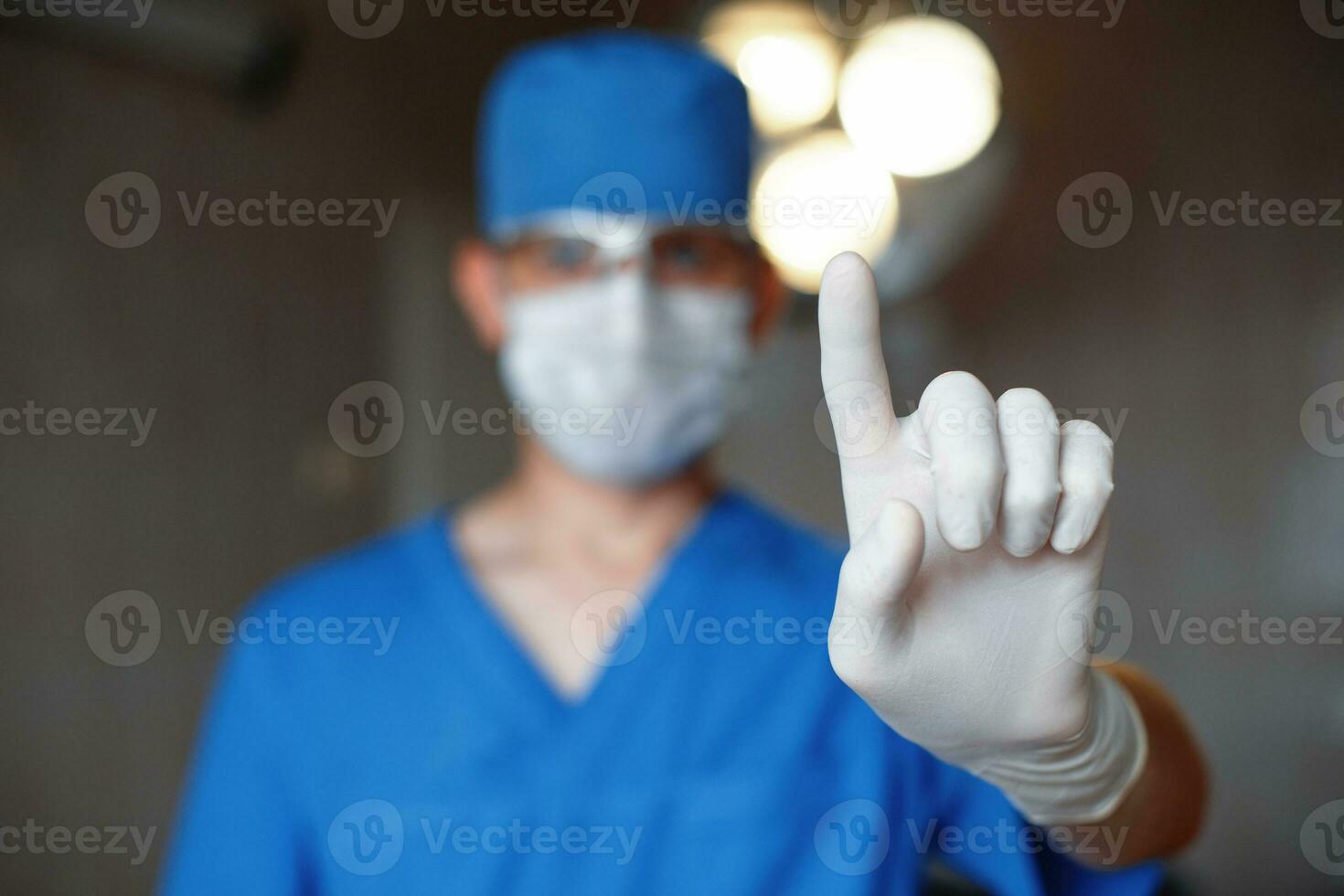 Doctor warns of danger and shows the index finger. The surgeon informs the warning. photo