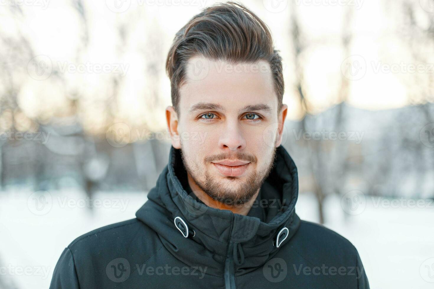 Men's handsome face with hair and beard in winter sunny day photo