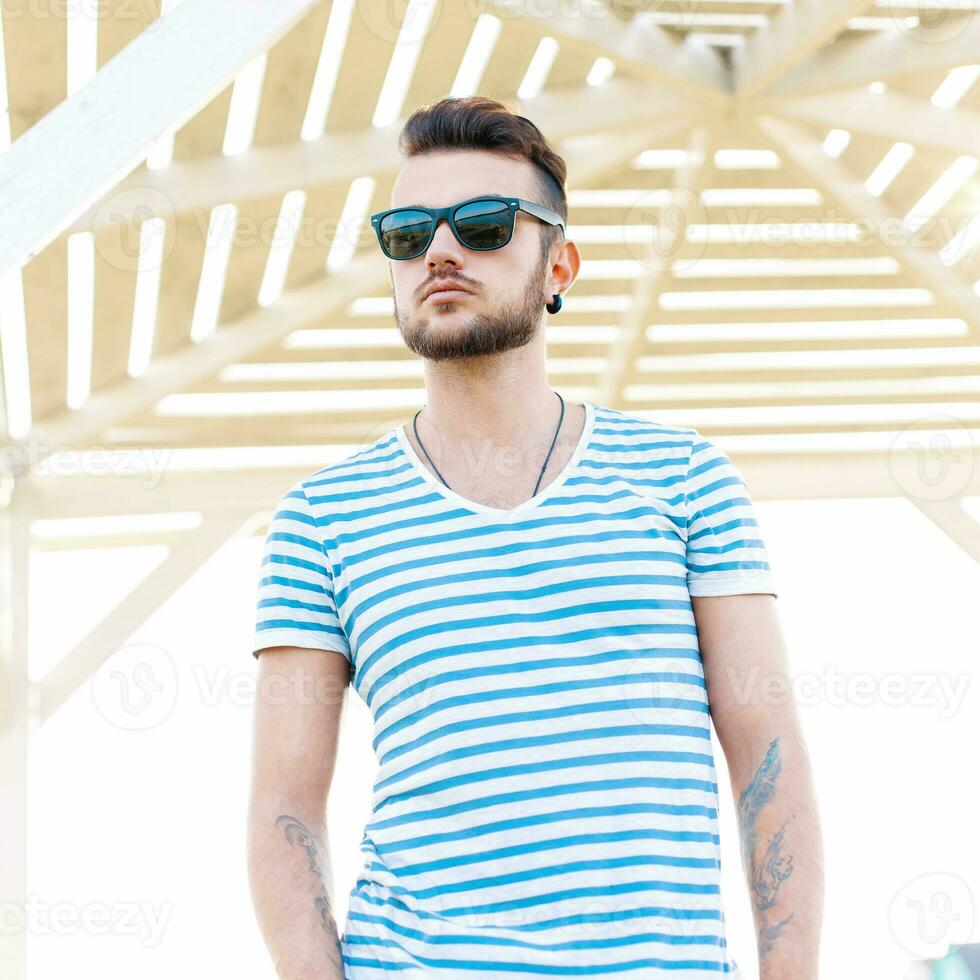 hermosa elegante hipster hombre en pie en el playa. foto