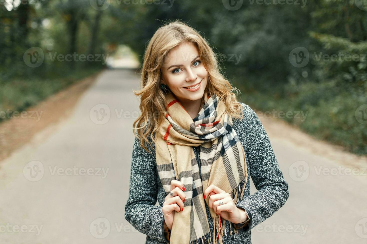 contento joven niña en un Saco y Clásico bufanda en otoño parque foto