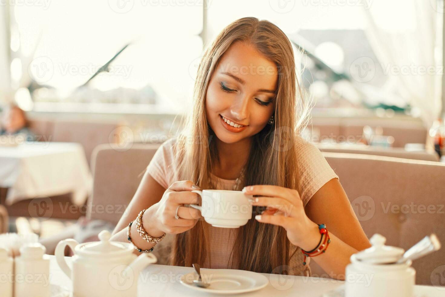 Woman with a smile drinking tea in the restaurant. photo