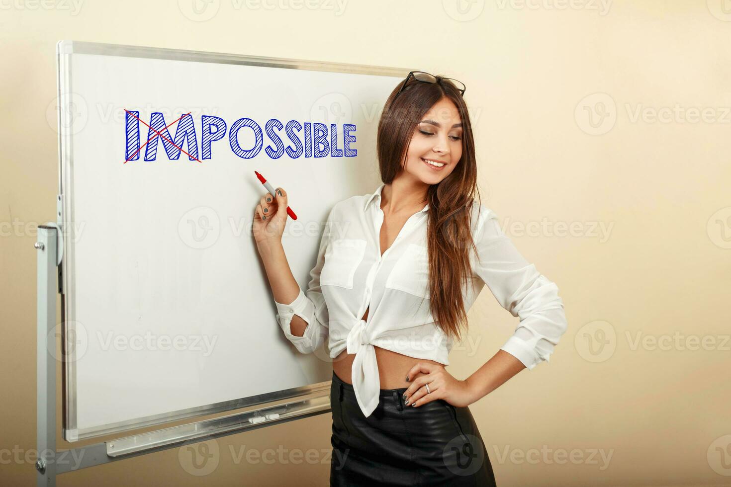 Beautiful woman writes the word possible on a white board with blue marker. The concept of possible. Impossible photo