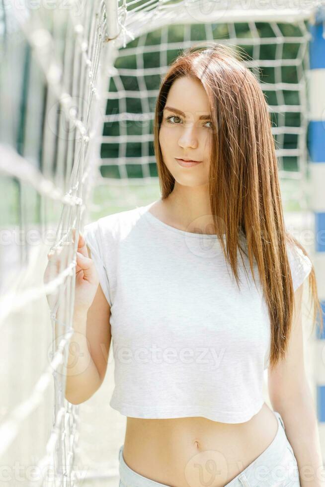 Beautiful sexy hipster girl near a beach grid photo