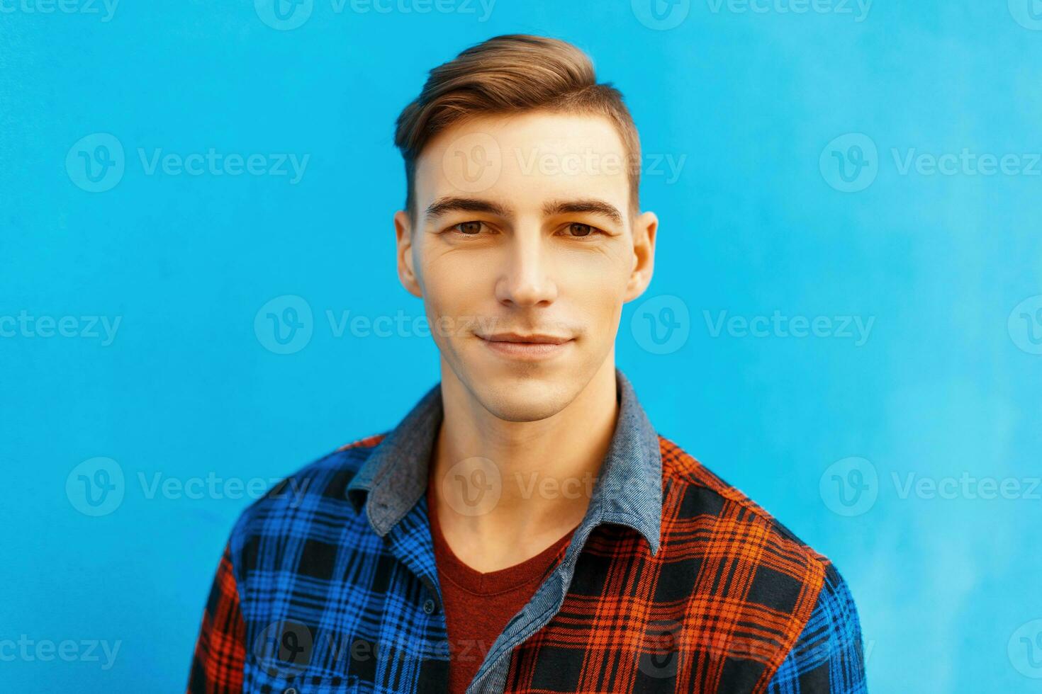 Portrait of a young handsome man in stylish shirt on a blue background. photo