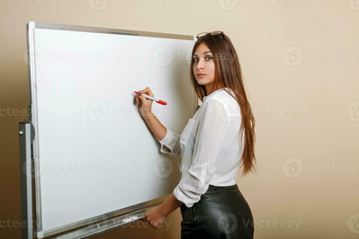 Beautiful sexy young woman writes on the whiteboard. Empty space photo