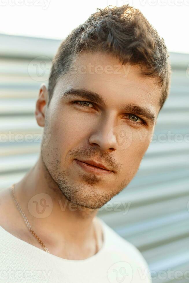 Close-up portrait of a handsome young guy with a beard in a summer day. photo