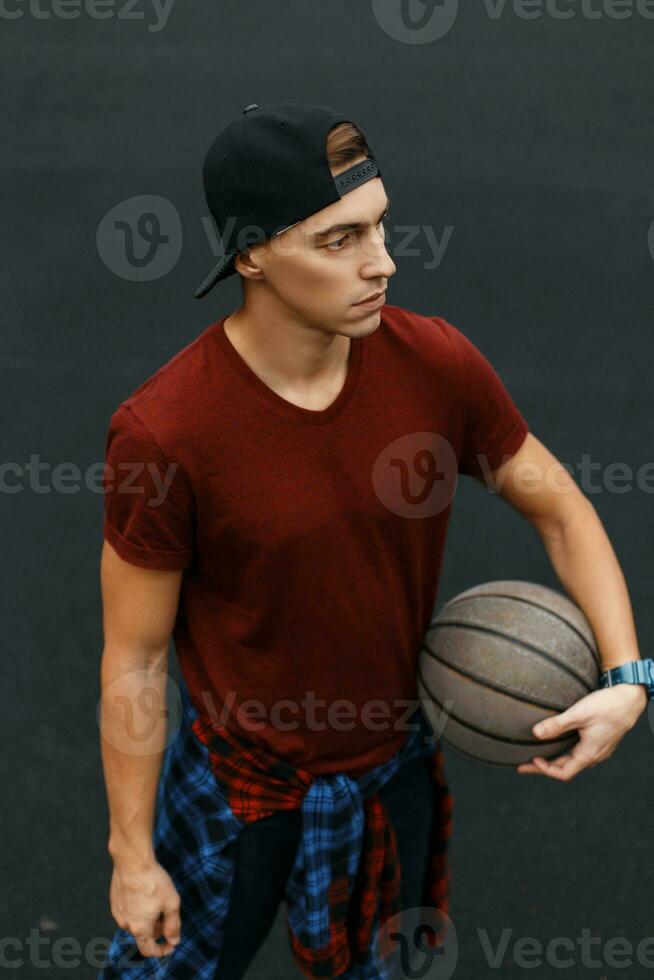 Handsome guy playing basketball, outdoors photo