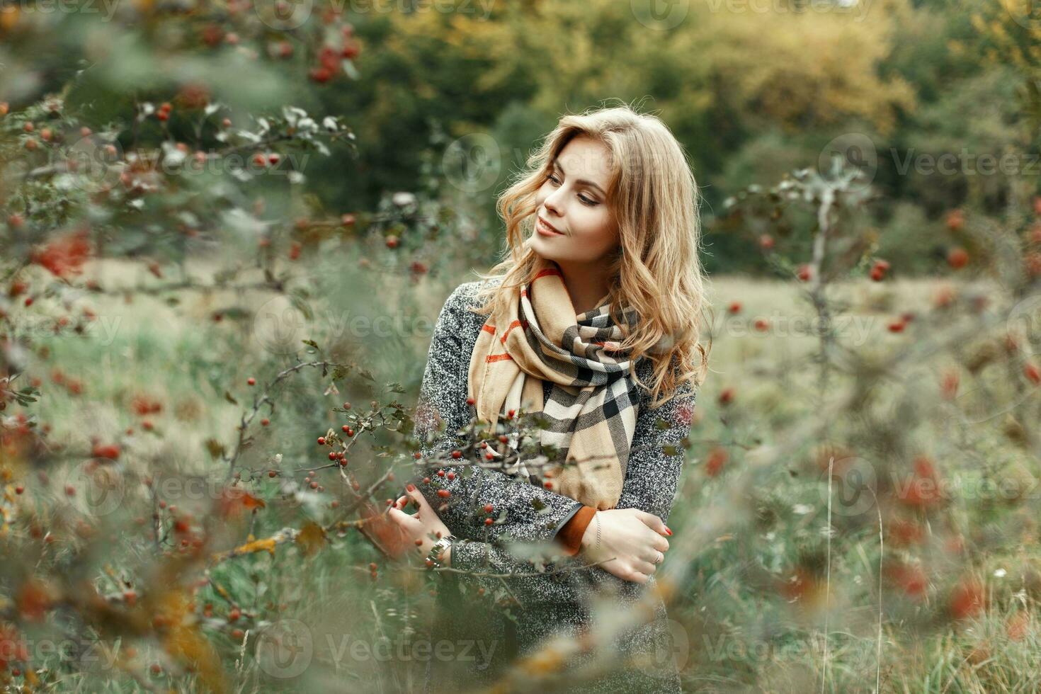 Pretty woman in autumn clothes posing in the garden. photo