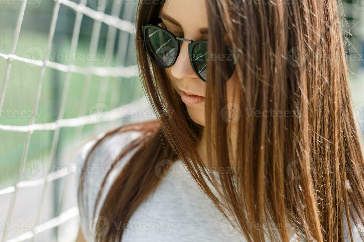 Close-up portrait of a young beautiful woman in stylish fashion sunglasses in the summer sunny day. photo