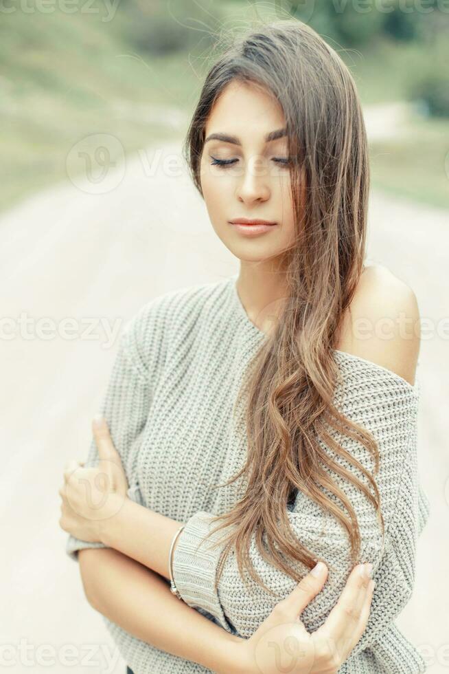 Beautiful young female model with the hairstyle in a warm knitted sweater photo