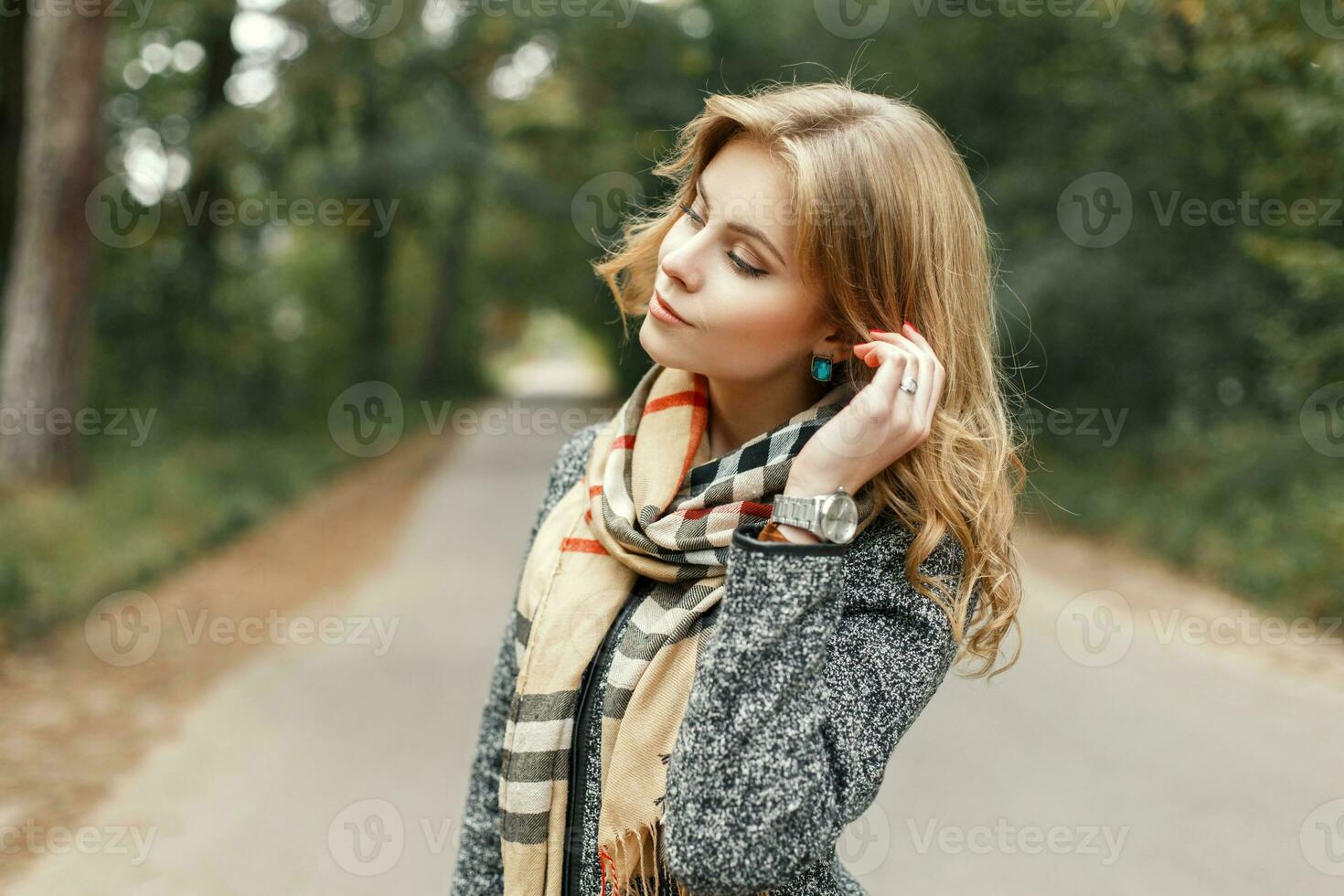 Beautiful woman in autumn vintage scarf posing in the park photo
