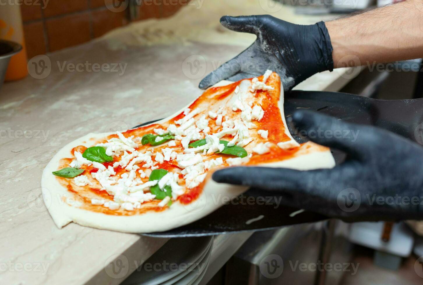 Raw margherita pizza on baking shovel. photo